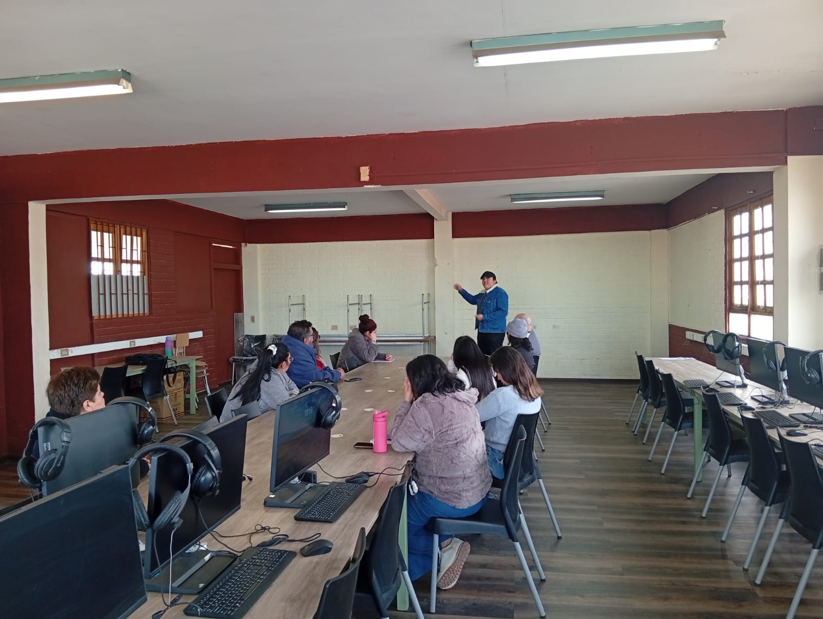 Apoderados y vecinos conversan alrededor de una mesa durante el taller de Amplia en el Colegio Quitalmahue